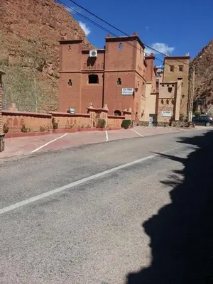 an empty street in front of a brick building at Riad Atlas Berbère in Boumalne