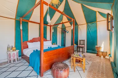 a bedroom with a canopy bed in a tent at Sahara Magic Camp in Merzouga