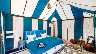 a room with a bed in a tent at Sahara Magic Camp in Merzouga