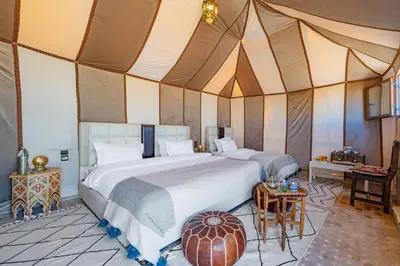 a bedroom with a large bed in a tent at Sahara Magic Camp in Merzouga