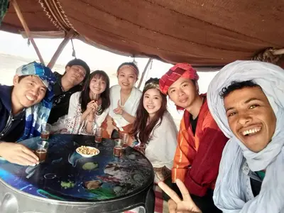 a group of people sitting around a table at Sahara Magic Camp in Merzouga