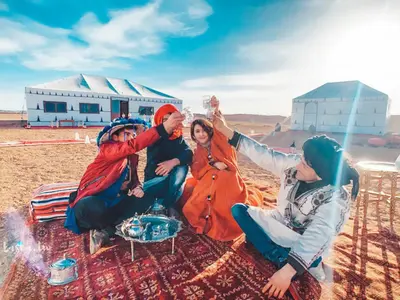 a group of people sitting on a blanket at Sahara Magic Camp in Merzouga