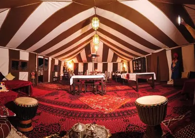 a woman standing in the middle of a room with a tent at Sahara Magic Camp in Merzouga