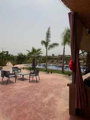 a patio with chairs and a table and a pool at chez JM saida in Ourika