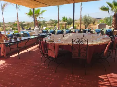 a table with wine glasses on it on a patio at chez JM saida in Ourika