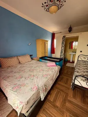 a bedroom with a large bed and a table at chez JM saida in Ourika
