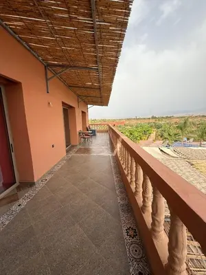 a balcony of a building with tables and chairs at chez JM saida in Ourika