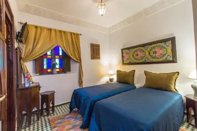 a bedroom with two beds and a window at Dar Fes Medina Ziat in Fès