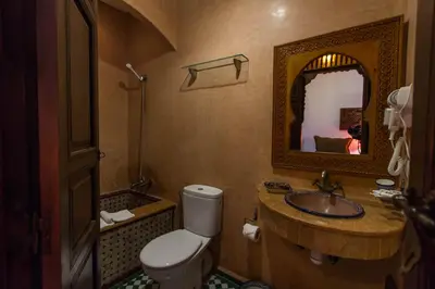 a bathroom with a toilet and a sink and a mirror at Dar Fes Medina Ziat in Fès