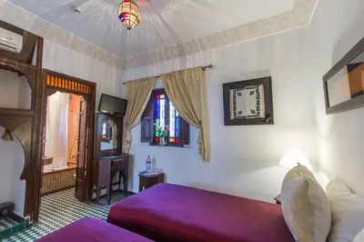 a bedroom with a purple bed and a window at Dar Fes Medina Ziat in Fès