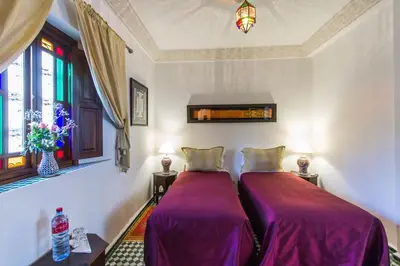 two beds in a room with purple sheets at Dar Fes Medina Ziat in Fès