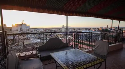 a table and chairs on a balcony with a view at Dar Meknes Tresor in Meknès