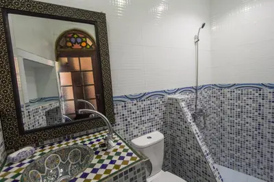 a bathroom with a sink and a mirror and a toilet at Dar Meknes Tresor in Meknès