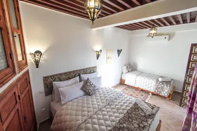 a bedroom with a bed and a couch in it at Dar Meknes Tresor in Meknès