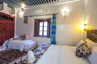 a bedroom with two beds and a window at Dar Meknes Tresor in Meknès