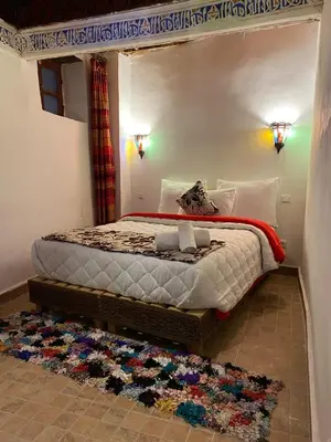 a bedroom with a canopy bed with a rug at Dar Meknes Tresor in Meknès