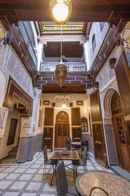 an empty room with tables and chairs in a building at Dar Meknes Tresor in Meknès