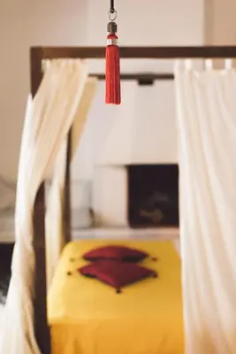 a bed with a red tassel hanging over it at Riad Tizwa Fes in Fès