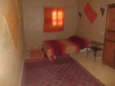 a small bedroom with a bed and a window at Camel Trek Bivouac in Merzouga