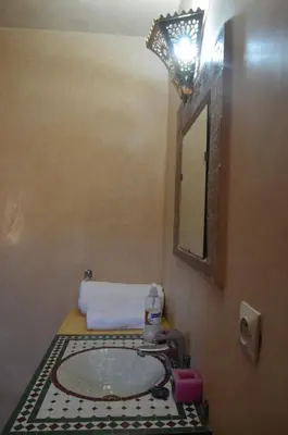 a bathroom with a sink and a mirror at Riad Oumkaltoum Fès in Fès