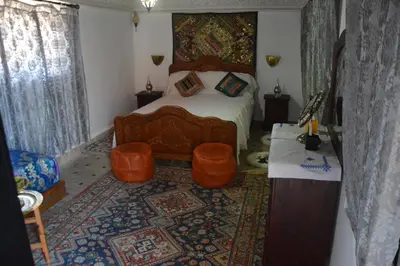 a bedroom with a bed and a rug at Riad Oumkaltoum Fès in Fès