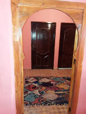 an entrance to a room with two doors and a rug at Auberge Restaurant Les Coquelicots in Aït Tamellil