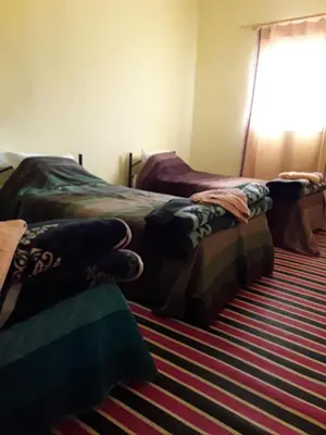 two beds sitting next to each other in a room at Auberge Restaurant Les Coquelicots in Aït Tamellil