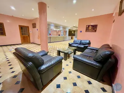 a living room with two leather chairs and a table at Hôtel Plaisance in Meknès
