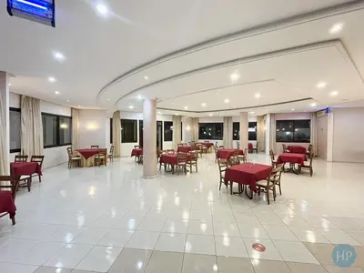 a restaurant with tables and chairs in a building at Hôtel Plaisance in Meknès
