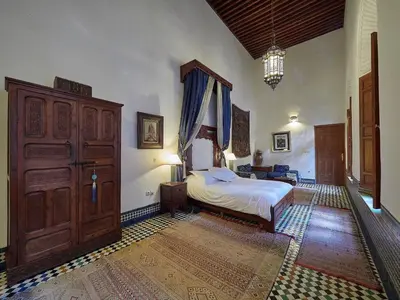 a bedroom with a bed and a large wooden cabinet at Dar Roumana in Fès
