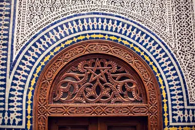 a wooden door with a cross on top of it at Dar Roumana in Fès