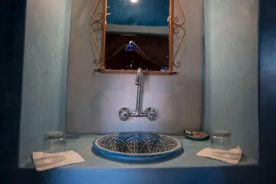 a bathroom with a sink and a mirror at Auberge Sahara Garden in Lac Yasmins