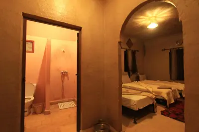 a room with two beds and a mirror at Auberge Sahara Garden in Lac Yasmins