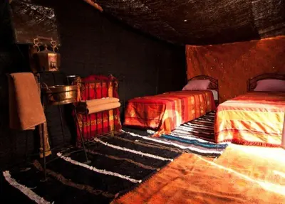 a bedroom with two beds and a rug at Auberge Sahara Garden in Lac Yasmins