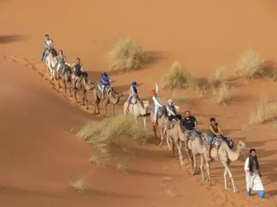 a group of people riding on horses in the desert at Auberge Sahara Garden in Lac Yasmins