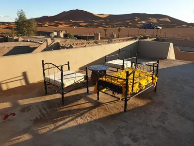 two beds on top of a building in the desert at Auberge Sahara Garden in Lac Yasmins