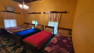 three beds sitting in a room with windows at Auberge Jbel Raids in Tagoudit