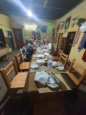 a group of people sitting at a long wooden table at Auberge Jbel Raids in Tagoudit
