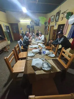a group of people sitting at a long wooden table at Auberge Jbel Raids in Tagoudit