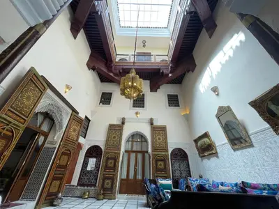 a large room with wooden doors and a chandelier at Riad AlKATIB Meknès in Meknès