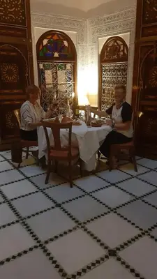 two people sitting at a table in a room at Riad AlKATIB Meknès in Meknès