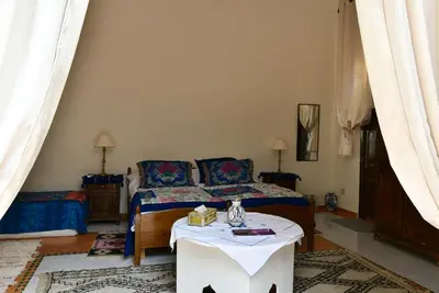 a bedroom with a bed and a table in it at Riad AlKATIB Meknès in Meknès