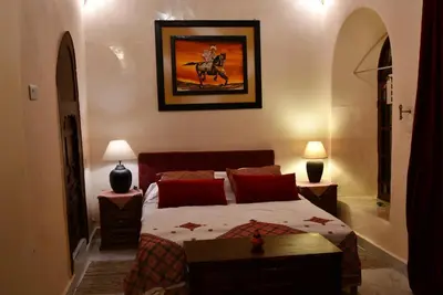 a bedroom with a bed and a picture of a horse at Riad AlKATIB Meknès in Meknès