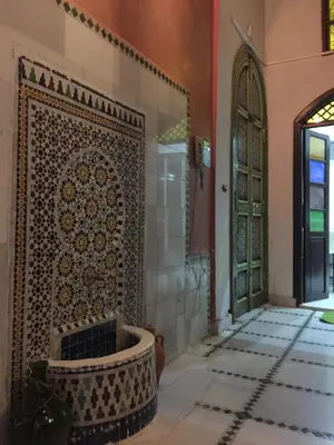 a room with a tile wall and a door at Riad AlKATIB Meknès in Meknès
