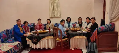 a group of people sitting around a table with food at Riad AlKATIB Meknès in Meknès