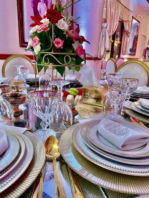 a table with plates and glasses and a vase of flowers at Hôtel Relais Saiss in Sefrou