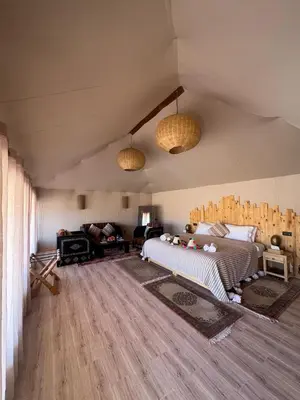 a bedroom with a bed and a living room at Desert Luxury Camp Erg Chigaga in El Gouera