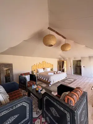 a bedroom with a bed and two couches at Desert Luxury Camp Erg Chigaga in El Gouera