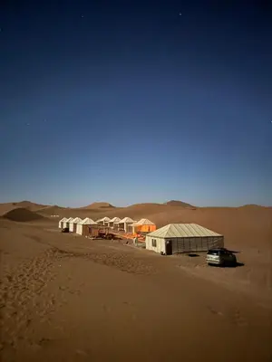 a group of buildings in the middle of the desert at Desert Luxury Camp Erg Chigaga in El Gouera
