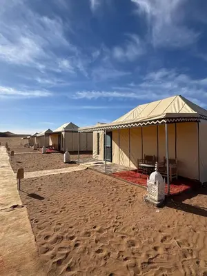 a row of tents in the middle of the desert at Desert Luxury Camp Erg Chigaga in El Gouera